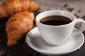 Two fresh croissants and cup of coffee on dark stone table Royalty Free Stock Photo