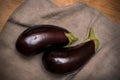 Two fresh eggplants on fabric at wooden table Royalty Free Stock Photo