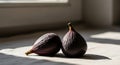 Two fresh figs (Ficus carica) with dark purple skin rest on a light-colored fabric Royalty Free Stock Photo