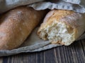 Two fresh French homemade baguettes under a linen towel