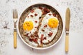 Two fresh fried eggs with crunchy crisp bacon served on rustic plate Royalty Free Stock Photo