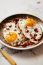 Two fresh fried eggs with crunchy crisp bacon served on rustic plate Royalty Free Stock Photo