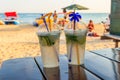 Two fresh mojito cocktails on table on a background of tropical beach Royalty Free Stock Photo