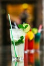 Two fresh mojitos cocktail on wooden background. Mojitos with mint leaves, lime and ice.