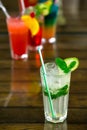 Two fresh mojitos cocktail on wooden background. Mojitos with mint leaves, lime and ice.