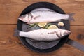 Two fresh moronidae fish on frying pan with ingredient Royalty Free Stock Photo