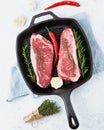 Two fresh raw big whole pieces of meat, beef fillet, marble striploin in cast-iron large pan