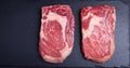 Two fresh raw marble meat, black Angus ribeye steak on a dark stone background. Royalty Free Stock Photo