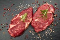 Two fresh raw marble meat, black Angus ribeye steak with spices on a dark stone background Royalty Free Stock Photo