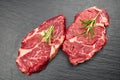 Two fresh raw marble meat, black Angus ribeye steak with spices on a dark stone background Royalty Free Stock Photo