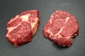 Two fresh raw marble meat, black Angus ribeye steak with spices on a dark stone background Royalty Free Stock Photo