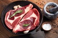 Two fresh raw marble meat, black Angus ribeye steak with spices in iron pan on a old rustic table. Raw beef on a wooden Royalty Free Stock Photo