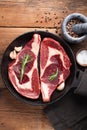 Two fresh raw marble meat, black Angus ribeye steak with spices in iron pan on a old rustic table. Raw beef on a wooden background Royalty Free Stock Photo