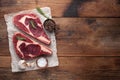 Two fresh raw marble meat, black Angus ribeye steak with spices on a old rustic table. Raw beef on a wooden background Royalty Free Stock Photo