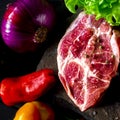 Two fresh raw ribeye steak on the stone on wooden background with salt, pepper