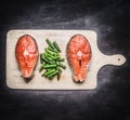 Two fresh raw salmon steak with green beans on cutting board top view Royalty Free Stock Photo