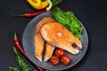 Two fresh raw salmon steaks with vegetables and spices: rosemary, tomatoes, peppers, basil, lemon and olive oil Royalty Free Stock Photo