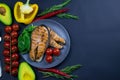 Two fresh raw salmon steaks with vegetables and spices: rosemary, tomatoes, peppers, basil, lemon and olive oil Royalty Free Stock Photo