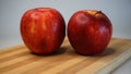 Two fresh red apples on wooden kitchen board Royalty Free Stock Photo