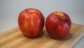 Two fresh red apples on wooden kitchen board Royalty Free Stock Photo