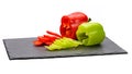 two fresh red and green bell peppers, cut into rings on a black board made of natural slate Royalty Free Stock Photo