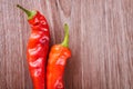 Two fresh red hot chili peppers on a wooden background Royalty Free Stock Photo