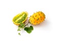 Two fresh ripe kiwano with vine and leaves, Cucumis metuliferus, isolated on white background