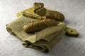 Two fresh rye buns on a cutting wooden board and a piece of burlap one of the buns is cut there is a knife next to it