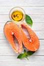 Two fresh salmon steaks with olive oil and Basil on a wooden white background - diet and healthy food Royalty Free Stock Photo