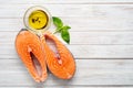 Two fresh salmon steaks with olive oil and Basil on a wooden white background - diet and healthy food Royalty Free Stock Photo