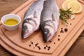 Two fresh sea bass fish on cutting board Royalty Free Stock Photo