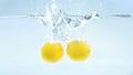 Two fresh yellow lemons falling deeply into water Royalty Free Stock Photo