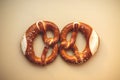 two freshly baked pretzels close-up, isolated on a beige background Royalty Free Stock Photo