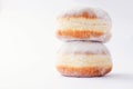 Two freshly made doughnuts, stack on top of each other, filled with jam and covered in powdered sugar Royalty Free Stock Photo