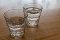 Two freshly poured glasses of sparkling water isolated on wood. Royalty Free Stock Photo