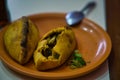 Two freshly prepared meat and vegetable saltenas served on plate