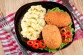 Two fried breaded cutlet with mashed potatoes and lettuce on a black plate wooden background Royalty Free Stock Photo