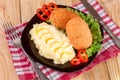 Two fried breaded cutlet with mashed potatoes and lettuce on a black plate wooden background Royalty Free Stock Photo