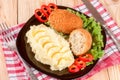 Two fried breaded cutlet with mashed potatoes and lettuce on a black plate wooden background Royalty Free Stock Photo