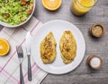 Two fried chicken breasts with curry, fresh orange juice, fresh salad nutrition athletes wooden rustic background top view Royalty Free Stock Photo