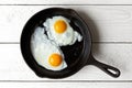 Two fried eggs in cast iron frying pan isolated on white painted Royalty Free Stock Photo