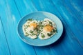 Two fried eggs for healthy breakfast in blue plate on blue wooden table Royalty Free Stock Photo