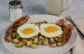 two fried eggs on home fries and bacon Royalty Free Stock Photo