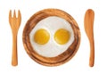 Two fried eggs on wooden plate, knife and fork isolated on white Royalty Free Stock Photo