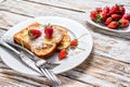 Two fried French toast with powdered sugar and strawberries. White background. Top view Royalty Free Stock Photo