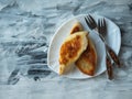 Two fried pies on a white curly plate with dessert forks ha on a wooden tray Royalty Free Stock Photo