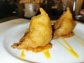 Two Samosas Served on a White Plate