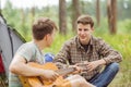 Two friend sitting in the tent, play the guitar and sing songs Royalty Free Stock Photo