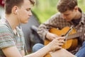 Two friend sitting in the tent, play the guitar and sing songs Royalty Free Stock Photo