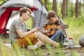 Two friend sitting in the tent, play the guitar and sing songs Royalty Free Stock Photo